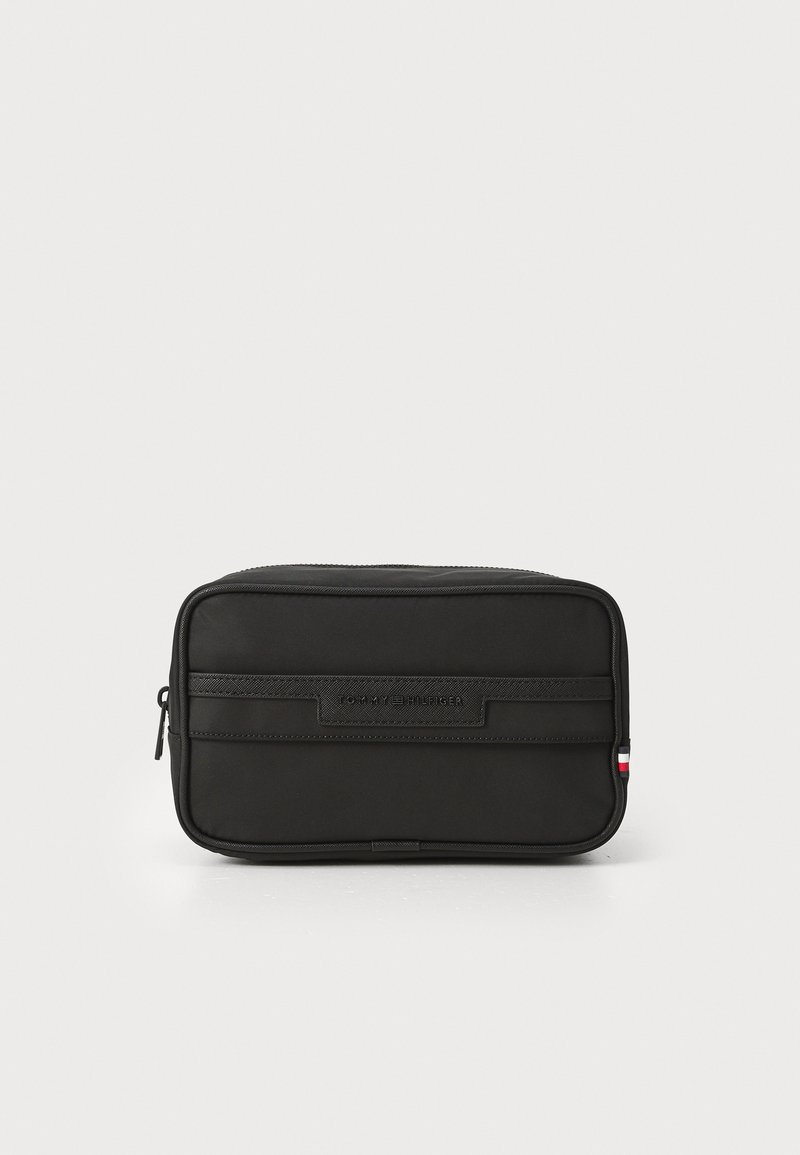 Trousse de toilette rectangulaire noire en tissu, dotée d'une texture lisse, d'une fermeture zippée et d'une bande noire avec un petit accent tricolore.