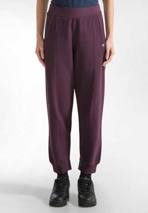 Pflaumenfarbene Sweatpants mit einem breiten elastischen Bund, Seitennaht und schmal zulaufenden Bündchen, aus einem weichen, atmungsaktiven Stoff gefertigt.