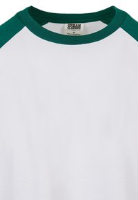 Weißes T-Shirt mit dunkelgrünen Raglanärmeln, rundem Halsausschnitt und organic Stoff. Mit einem Etikett mit dem Markennamen "Urban Classics" innen.
