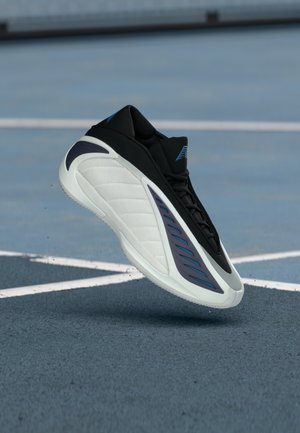 Czarny but sportowy z fakturowaną białą podeszwą, niebieskimi akcentami i aerodynamicznym designem, z charakterystycznym skrzydłopodobnym wzorem po boku.