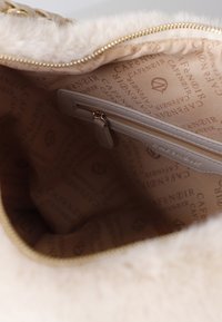 Beige nepbont handtas met een gladde, gevoerde binnenkant en een ritsvak. Binnenin staat de merknaam "CAFÉ NOIR" gedrukt.