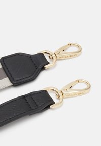 Black fabric strap with gold hardware clips. Includes a textured black leather accent and contrasting color stripe for added detail.