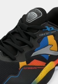 Black athletic shoe with colorful accents in orange, blue, and yellow. Features a textured upper, rubber sole, and a raised logo on the tongue.