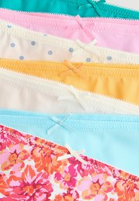 Assortiment van slips in frisse kleuren: teal, roze, crème met stippen, geel en een bloemenpatroon; sommige voorzien van decoratieve strikjes.