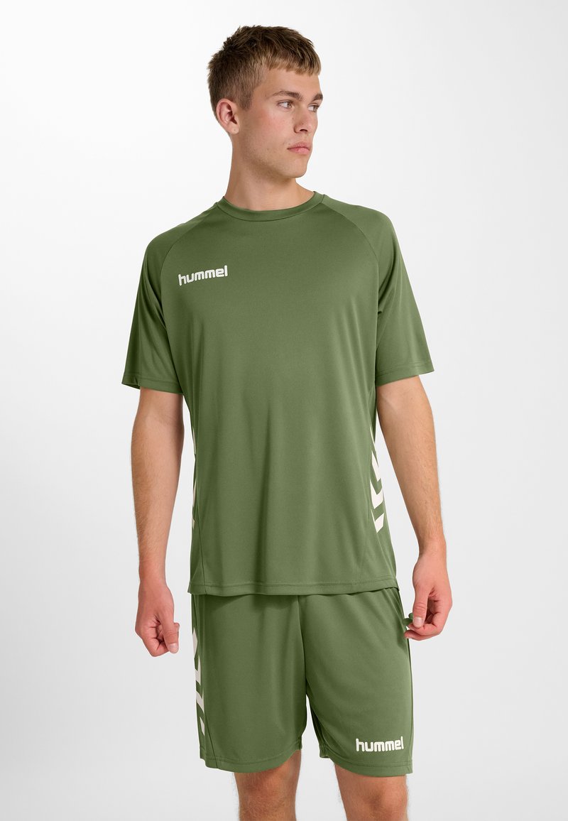 Groene sportoutfit bestaande uit een top met korte mouwen en een korte broek. Gemaakt van glad, lichtgewicht materiaal, met wit logo en chevron accenten.