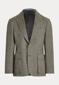 Blazer à un bouton avec motif chevrons en noir, blanc et beige, avec revers en encoche et deux poches plaquées à rabat à l'avant.