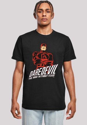 Schwarzes Baumwoll-T-Shirt mit einem grafischen Druck eines Superhelden in Rot und dem Logo "DAREDEVIL DER MANN OHNE ANGST!" in Weiß und Rot.