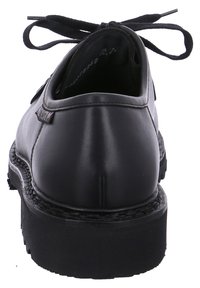 Chaussure noire en cuir avec lacets, à bout arrondi, texture lisse, semelle en caoutchouc épaisse, et un lacet noué à l'arrière pour la fermeture.