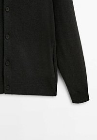Cardigan noir avec un tricot texturé, une fermeture à boutons, des poignets et un ourlet côtelés, ainsi qu'une poche latérale fendue. Tissu durable avec une finition lisse.