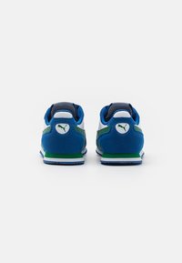 Baskets en daim bleu avec accents verts et blancs, dotées d'un col rembourré et d'un logo signature sur le talon. Semelle en caoutchouc à profil bas.