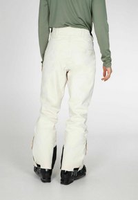 Witte sneeuwbroek met een relaxed fit, voorzien van zwarte accenten bij de enkels en een strakke, gladde textuur. Ideaal voor wintersporten.