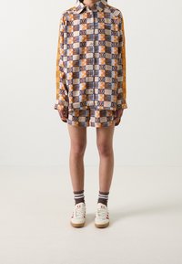 Kortärmad skjorta med krage och shorts i en uppsättning med geometriskt mönster i beige, orange och marinblått, med kontrasterande sidostripes.