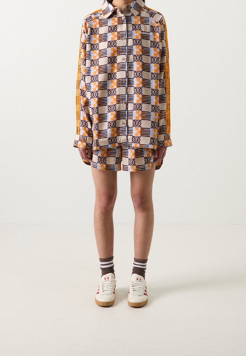 Kortärmad skjorta med krage och shorts i en uppsättning med geometriskt mönster i beige, orange och marinblått, med kontrasterande sidostripes.