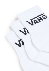 Calze bianche in cotone con texture a coste, caratterizzate da un logo nero "VANS" ben visibile sul bordo. Tre paia impilati.