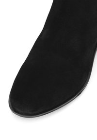 Must musta ankle boots, millelise suunaga ja siledal tekstuuril, millel on sujuv ja madal must tald.