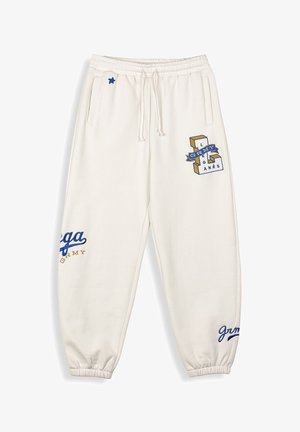 Cremefarbene Sweatpants mit elastischen Bündchen und Taillenbund, die blau-goldene Druckakzente und ein kleines Sternendesign aufweisen.