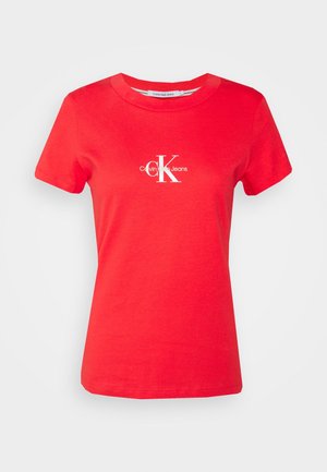 Rød bomulds T-shirt med rund halsudskæring. Har et hvidt Calvin Klein Jeans logo trykt på fronten, korte ærmer og en standard pasform.