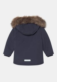 Granatowa parka z kapturem wykończonym futrem, elastycznymi mankietami oraz odblaskowym detalem na plecach. Gładka tekstura, średnia długość.