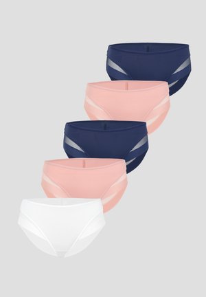 Femme portant un crop top rose clair et un sous-vêtement taille haute assorti avec des panneaux latéraux en mesh, debout sur fond blanc.