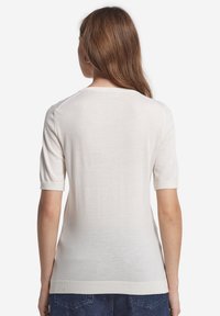Lys beige kortærmet sweater med rund halsudskæring, lavet af et glat materiale. Har optrukne ærmer og en tætsiddende design.