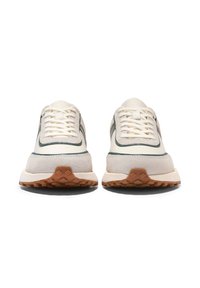 Sneaker mit einer cremefarbenen Oberseite und grünen Akzenten, aus Wildledermaterial, strukturiertem Gummisohle und flachen Schnürsenkeln. Wildlederverkleidung nahe der Ferse.