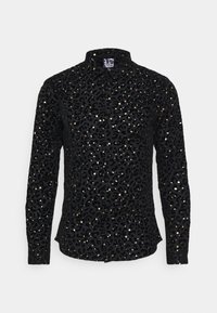 Černá halenka s dlouhým rukávem a vzorem s leopardím potiskem, zdobená lesklými zlatými prvky a strukturovaným límcem. Texturovaná tkanina dodává hloubku.