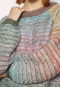 Maglione lavorato a maglia multicolore con un design texturizzato, caratterizzato da tonalità varie tra cui verde, rosa e arancione, con polsini e scollo a coste.