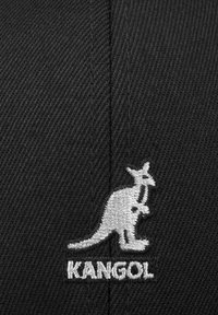 Cappello in tessuto nero con un motivo testurizzato, dotato di un logo canguro ricamato in bianco e la scritta "KANGOL" sotto.