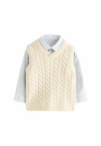Gilet en tricot crème à torsades avec un col en V, superposé à une chemise à col rayée bleu clair et blanche avec des poignets à boutons.