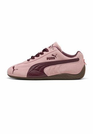 Lage Puma sneaker in lichtroze suède met donkerpaarse leren details, bijpassende veters en bruine rubberen zool, zijaanzicht.