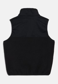 Colete preto sem mangas com um colarinho alto, apresentando uma parte inferior em fleece suave e uma parte superior lisa e texturizada.