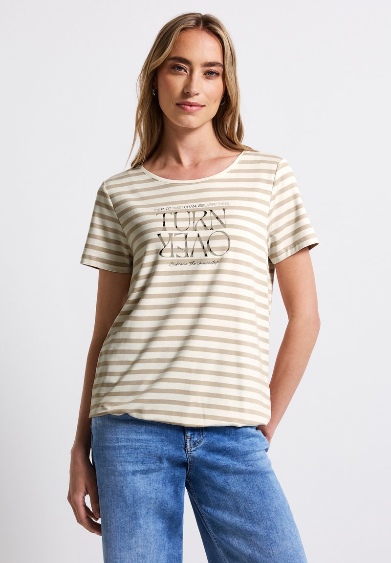 T-shirt rayé beige clair en tissu doux, avec des manches courtes et un col rond. Texte graphique imprimé sur le devant.
