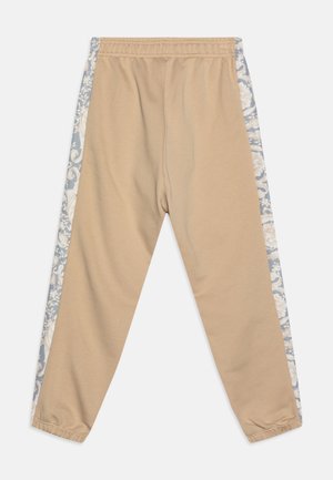 Beżowe spodnie z elastycznym pasem i mankietami, z niebiesko-białymi bocznymi panelami w kwiatowy wzór.