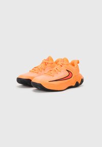 Des chaussures de sport orange vif en mesh et en matière synthétique, avec un design de semelle ondulée et des accents noirs sur les côtés.