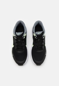 Baskets Nike en mesh noir avec des accents vert néon, doublure intérieure grise et lacets noirs ; équipées d'une semelle blanche rembourrée.