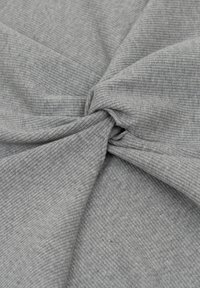 Szary, teksturowany materiał z prążkowanym wzorem, skręcony w centrum, prezentujący miękką, lekką tkaninę.