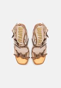 Brune metalliske sandaler med firkantet tå, som har dekorative sommerfugl-detaljer og tynne stropper som sikrer ankelen. MERKET såle.