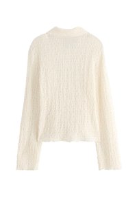 Lett, tekstureret cremede sweater med et bølget mønster, lange ærmer og en blød krave, der har en løstsiddende pasform.