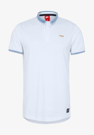 Polo shirt blanc avec un design col, présentant un col et des poignets de manches à rayures bleues. Comprend un petit logo doré à l'avant.