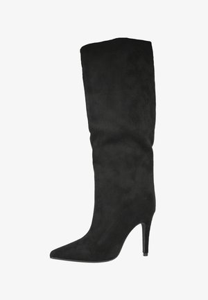 Bota de tacón stiletto de ante negro hasta la rodilla, con una puntera afilada, que presenta una superficie lisa y una silueta ajustada. Sin herrajes ni patrones visibles.