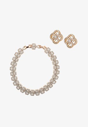 Goldarmband und passende Ohrstecker mit filigranen Blumenmustern, besetzt mit kleinen funkelnden Diamanten.