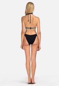 Czarny dwuczęściowy kostium kąpielowy z górą na szyję, ozdobioną paskami i regulowanym zapięciem, w zestawie z majtkami o wysokim kroju z boku z elementami metalowymi.