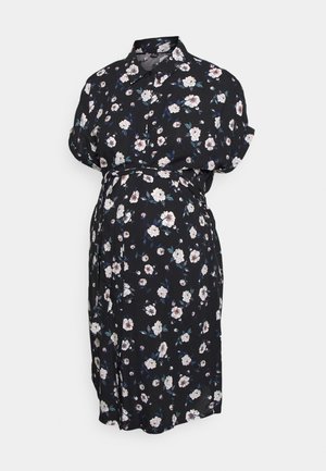 Vestido floral preto feito de tecido leve. Apresenta mangas curtas dobradas, colarinho com botões, faixa na cintura e padrão floral branco com acentos verdes.