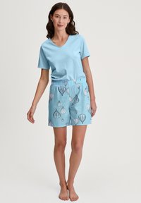Lichtblauw katoenen t-shirt met een V-hals, gecombineerd met shorts met elastische tailleband in lichtblauw met een patroon van gestileerde luchtballonnen.