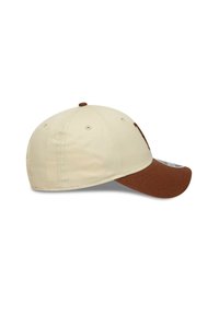 Gorra de béisbol beige con visera marrón. Sus características incluyen detalles bordados, agujeros de ventilación y una parte superior redondeada. Material de tela texturizada.