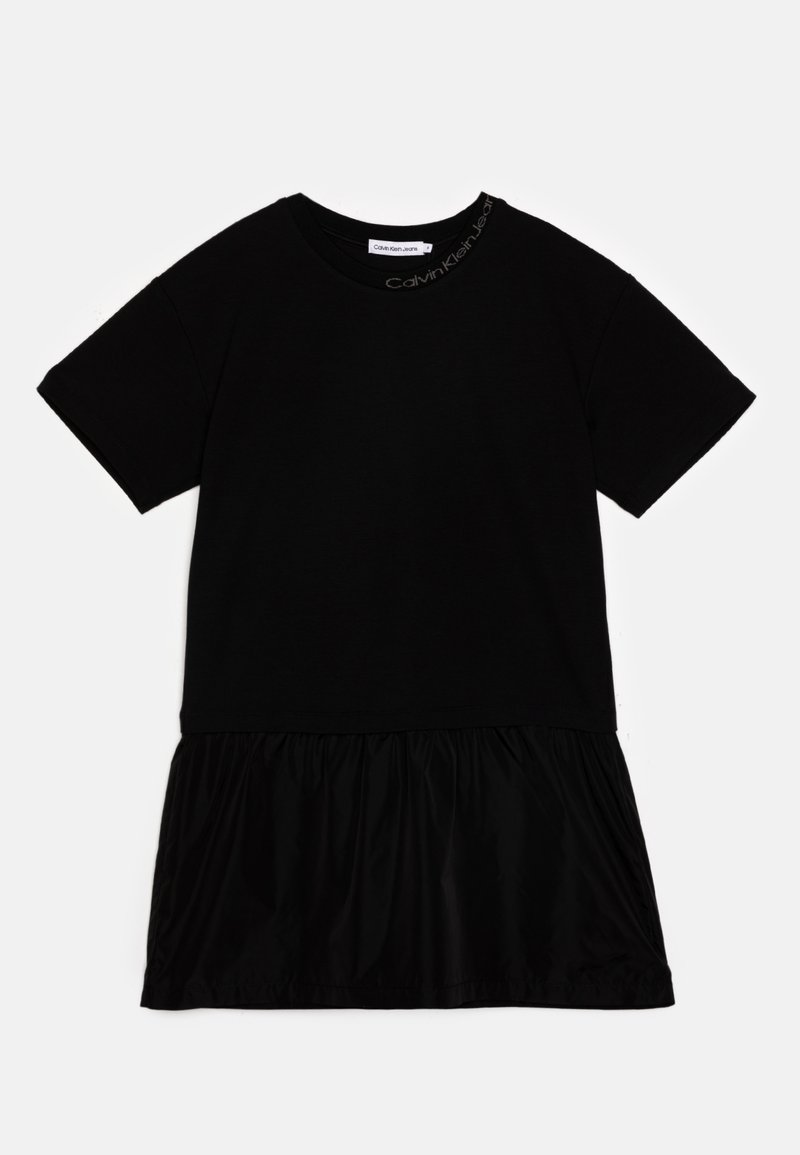 Must must koos pehme puuvillase ülaosa, millel on lühikesed varrukad ja volditud, voolav seelikuosa kergest kangast. Calvin Kleini logo kaelaõmblusel.