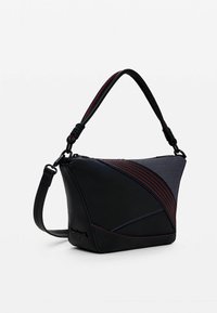 Bolso de mano negro con diseño geométrico, que presenta una mezcla de texturas de materiales lisos y de malla, acentuado con costuras rojas y azules. Correa ajustable.