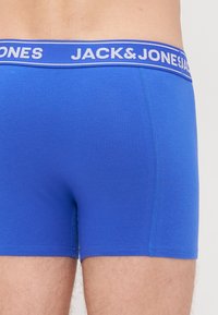 Boxer in cotone azzurro con una cintura a contrasto bianca con il marchio "JACK & JONES". Texture liscia e design aderente.