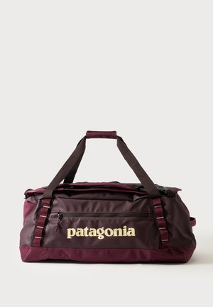 Borsa da viaggio Patagonia color mogano con tasca frontale con zip e doppi manici, su sfondo chiaro uniforme.