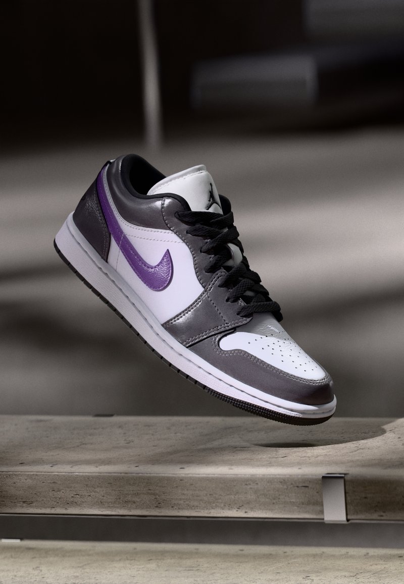 Nike Air Jordan 1 bateliai turi baltą odinį priekinį bandą, pilkas odines šonines dalis ir purpurinį swoosh, su juodais raišteliais ir guminiu padu.